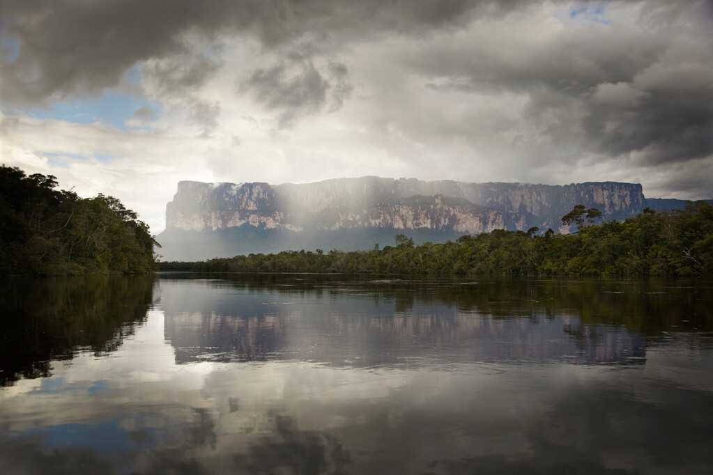 Tepuis, large flat topped mountains, stand all along the winding Canaima River, in Canaima National Park, Venezuela. Auyantepui seen here is home to Angel Falls